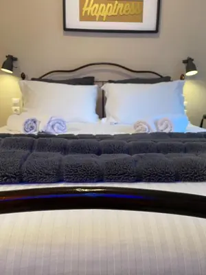 a bed with white pillows and purple roses on it at Elegant Hermes Suite in Athens, by Acropolin in Athens