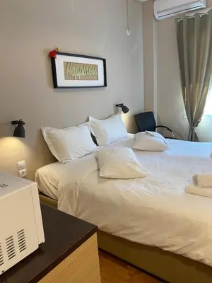 a bedroom with two beds and a desk with a computer at Elegant Hermes Suite in Athens, by Acropolin in Athens