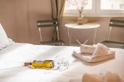 a bottle of champagne and a towel on a bed at Elegant Hermes Suite in Athens, by Acropolin in Athens