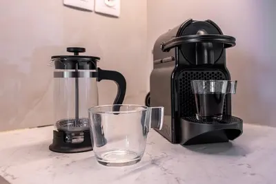 a coffee maker and a glass on a counter at Modern 1BR - 19min to Center, Fiber Internet in Athens