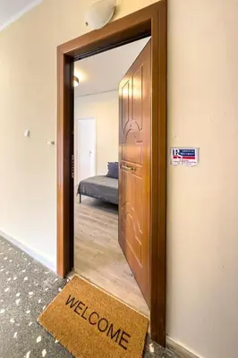 a door to a room with a welcome sign and a welcome mat at Modern 1BR - 19min to Center, Fiber Internet in Athens