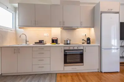 a kitchen with white cabinets and a refrigerator at Modern 1BR - 19min to Center, Fiber Internet in Athens