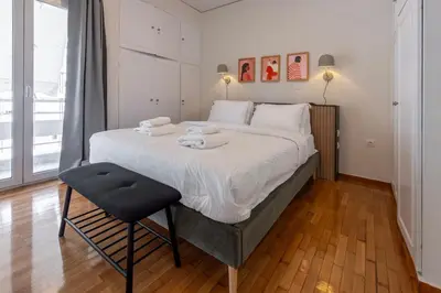 a bedroom with a large bed and a chair at Modern 1BR - 19min to Center, Fiber Internet in Athens