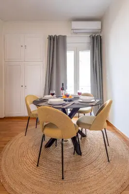 a dining room table with yellow chairs and a black table at Modern 1BR - 19min to Center, Fiber Internet in Athens