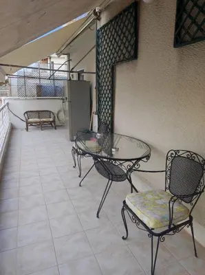 a patio with a glass table and two chairs at Onix 1 in Athens