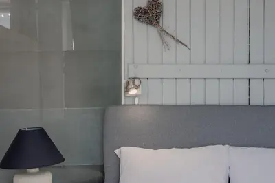a bedroom with a bed and a table with a lamp at Windows with view in Athens