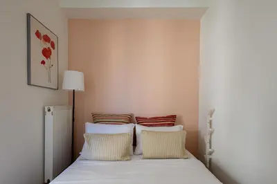 a bedroom with a bed with white sheets and red pillows at mylo akropoli views in Athens
