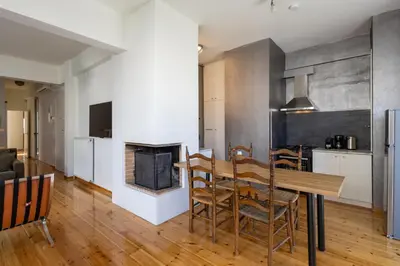 a kitchen and dining room with a table and a fireplace at mylo akropoli views in Athens
