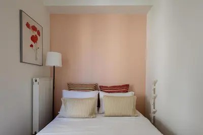 a bedroom with a bed with white sheets and red pillows at mylo akropoli views in Athens