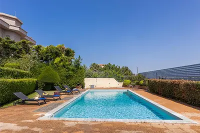 a swimming pool with two lounge chairs at Blue Horizon Villa in Kalívia Thorikoú