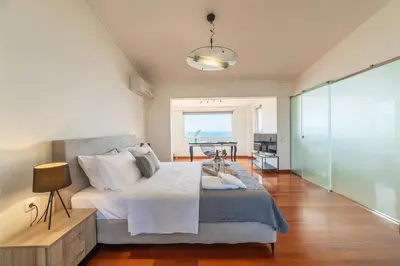 a bedroom with a bed with a table and a window at Blue Horizon Villa in Kalívia Thorikoú