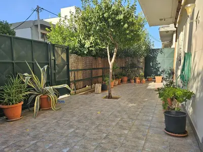 a courtyard with potted plants and a fence at Arkadiou Apartments in Chalandri in Athens