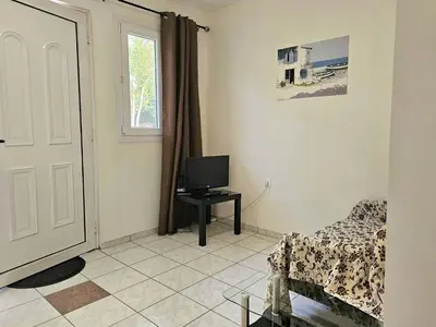 a living room with a tv and a couch and a window at Arkadiou Apartments in Chalandri in Athens