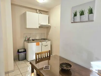 a small kitchen with a white refrigerator and a table at Arkadiou Apartments in Chalandri in Athens