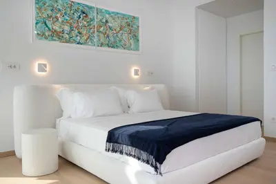 a white bedroom with a white bed with a blue blanket at The ROSE Luxury Penthouse with Private Swimming Pool in Athens