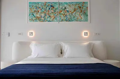 a bedroom with a bed with a painting on the wall at The ROSE Luxury Penthouse with Private Swimming Pool in Athens