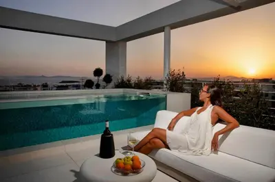 a woman sitting on a couch next to a pool at The ROSE Luxury Penthouse with Private Swimming Pool in Athens