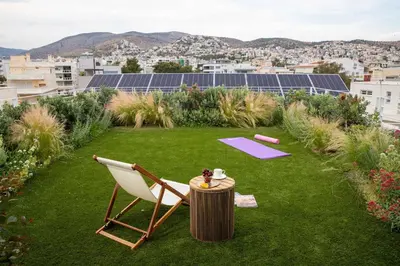 a lawn with a chair and a table and a yoga mat at The ROSE Luxury Penthouse with Private Swimming Pool in Athens