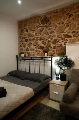 a bedroom with a bed and a brick wall at Tsigros Apartments B in Athens