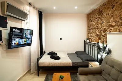 a bedroom with a bed and a flat screen tv at Tsigros Apartments B in Athens