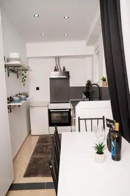 a kitchen with white cabinets and a white counter top at Tsigros Apartments B in Athens
