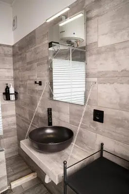 a bathroom with a black sink and a mirror at Tsigros Apartments B in Athens