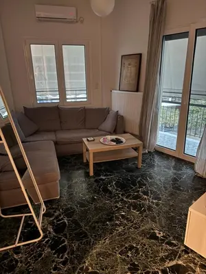 a living room with a couch and a table at Tataoulon 22, Nea Smirni in Athens
