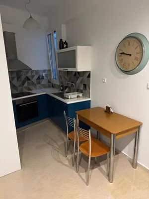 a kitchen with a table and a clock on the wall at Tataoulon 22, Nea Smirni in Athens