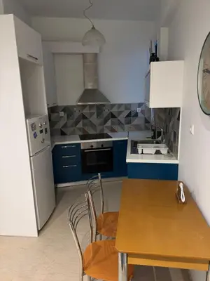 a kitchen with a wooden table and a refrigerator at Tataoulon 22, Nea Smirni in Athens