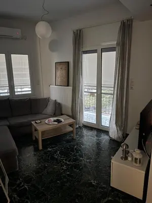 a living room with a couch and a table at Tataoulon 22, Nea Smirni in Athens