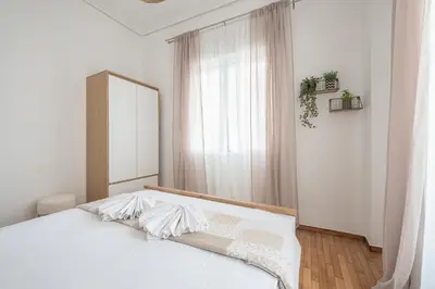 a bedroom with a bed with a mirror and a window at Ble Elia Thiseio Suite in Athens