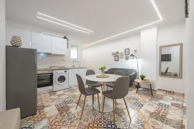 a kitchen and living room with a table and chairs at Ble Elia Thiseio Suite in Athens