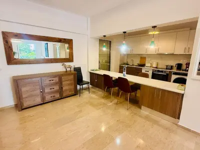 a large kitchen with a counter and chairs in it at \u96c5\u5178\u5357\u90e8\u6d77\u6ee82km\u7684\u8212\u9002\u5bbd\u655e\u516c\u5bd3 in Athens