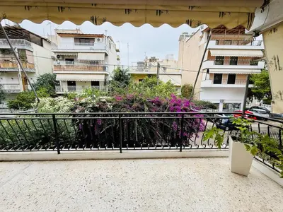 a balcony with flowers and buildings in the background at \u96c5\u5178\u5357\u90e8\u6d77\u6ee82km\u7684\u8212\u9002\u5bbd\u655e\u516c\u5bd3 in Athens
