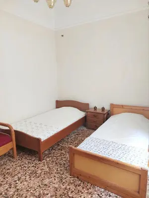 a bedroom with two beds and a chair at Room for 2 in a dormitory 5' from metro in Athens
