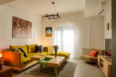 a living room with a yellow couch and a table at Urban comfort in Athens centre in Athens
