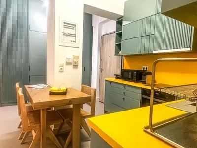 a kitchen with a wooden table and yellow counters at Urban comfort in Athens centre in Athens