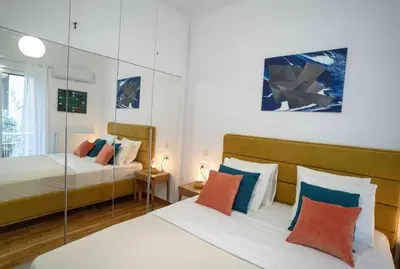a bedroom with two beds and a mirror at Urban comfort in Athens centre in Athens