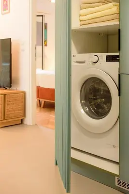 a washing machine in a room with a bedroom at Urban comfort in Athens centre in Athens