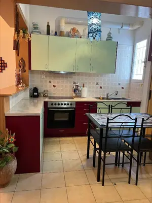 a kitchen with red cabinets and a table with chairs at Bohemian Athens home in Athens
