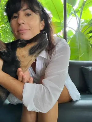 a woman is holding a dog in her lap at Bohemian Athens home in Athens
