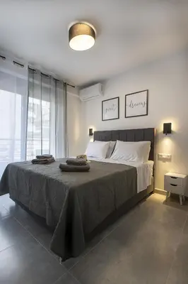 a bedroom with a large bed with towels on it at Black & White 2BR Apt steps from Mavili Square in Athens