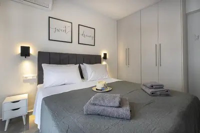 a bedroom with a large bed with towels on it at Black & White 2BR Apt steps from Mavili Square in Athens