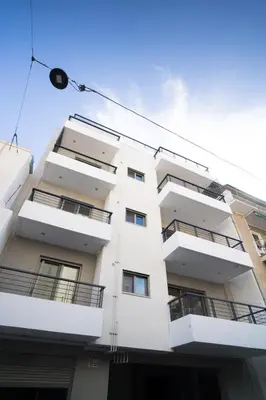 a white apartment building with balconies on it at Black & White 2BR Apt steps from Mavili Square in Athens