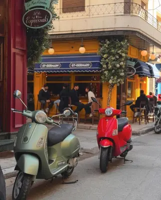two scooters parked on a street in front of a restaurant at Black & White 2BR Apt steps from Mavili Square in Athens