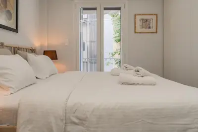 a white bed with two teddy bears sitting on it at Ilisia Urban Elegance in Athens