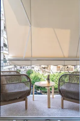 two benches and a table in front of a window at Ilisia Urban Elegance in Athens
