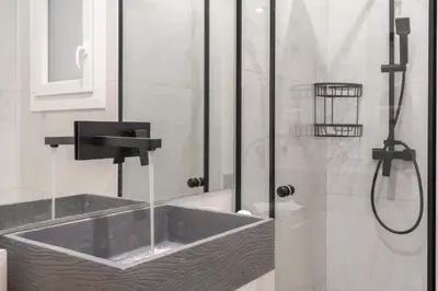 a bathroom with a shower with a sink and a tub at Ilisia Urban Elegance in Athens