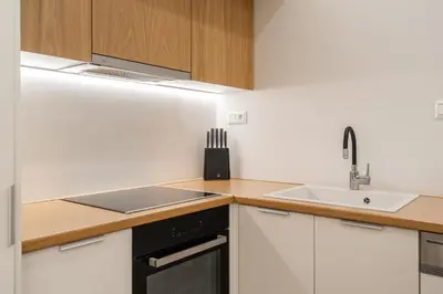 a kitchen with white cabinets and a sink at Ilisia Urban Elegance in Athens
