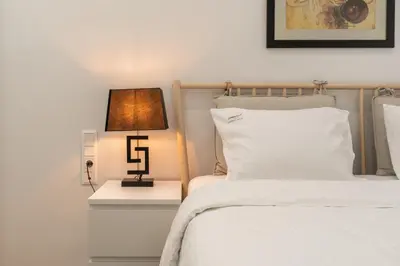 a bedroom with a bed and a lamp on a night stand at Ilisia Urban Elegance in Athens
